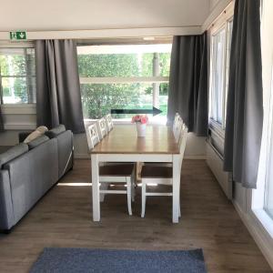 a dining room with a table and chairs and a couch at Pohjoiskeskus 9 in Oulu