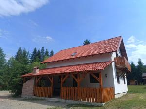 a small house with a red roof at Csencsó Vendégház in Ciumani