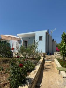 a house with a garden with flowers and an umbrella at Vila Bedro in Sarandë