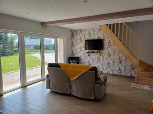 a living room with a couch and a tv at Fermette au calme in Arras