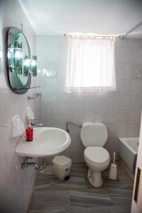 um banheiro com um vaso sanitário branco e uma pia em Cozy and calm em Dhílesi mais 38 fotografias