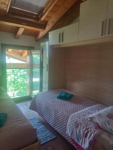 a bedroom with two beds and a large window at Appartamento Orchidea Garda in Garda