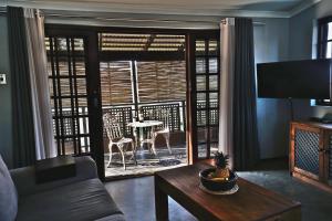 a living room with a couch and a table and a window at Villa La Mercy Chalet No load shedding or water outages in La Mercy