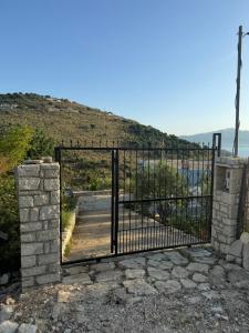 a black gate with a stone wall at Vila Bedro in Sarandë