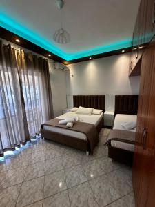 een slaapkamer met 2 bedden en blauwe verlichting bij Ylli's Apartments in Sarandë