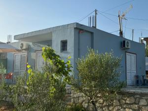 a blue house with trees in front of it at Vila Bedro in Sarandë