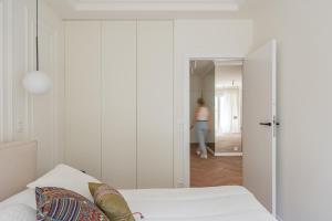 a woman is walking into a room with a bed at Apartament PREMIUM in Poznań +8 photos
