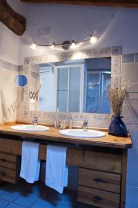 uma casa de banho com 2 lavatórios e um espelho grande em La Llar D'aitana em Alcoleja