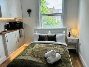 a bedroom with a bed with towels on it at Zee homes W6 in London
