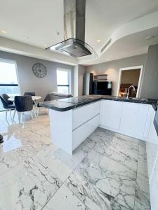 - une cuisine avec des placards blancs et un sol en marbre dans l'établissement Mercury Tower 709, à San Ġiljan