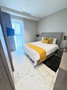 une chambre avec un grand lit avec des oreillers jaunes dans l'établissement Mercury Tower 709, à San Ġiljan