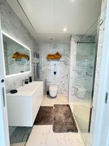 une salle de bain avec un lavabo blanc et une douche dans l'établissement Mercury Tower 709, à San Ġiljan