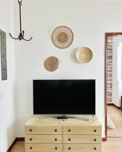 een flatscreen-tv op een houten dressoir bij Fisherman´s Cave in Faro