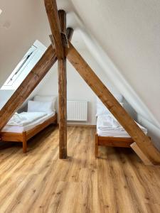 two beds in a attic room with wooden floors at Ferienwohnung im Grünen Haus in Herbolzheim