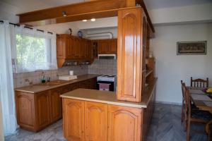 uma cozinha com armários de madeira e uma bancada em Cozy and calm em Dhílesi