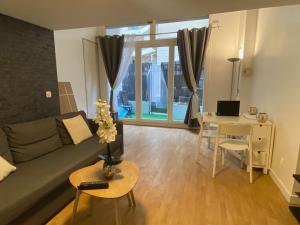 a living room with a couch and a table with a desk at Magnifique duplex 45 m2 aux portes de Paris Metro Barbara à 30mn Expo Porte de Versailles in Montrouge