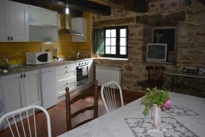 a kitchen with a table with a vase of flowers on it at La Casa de Rosa in Filiel