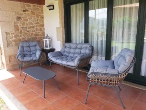 two chairs and a couch on a porch at Casa con vistas al mar in Noya