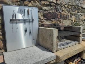 a refrigerator with utensils on it next to a stone wall at Casa con vistas al mar in Noya
