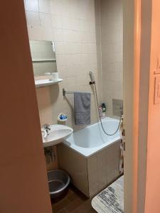a bathroom with a sink and a tub and a toilet at Urban Apartment in Sarajevo