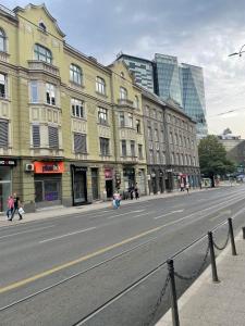 a city street with buildings and people walking down the street at Urban Apartment in Sarajevo
