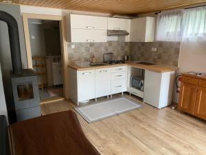a kitchen with white cabinets and a stove at SKH S, 1 apartment, 1 bedroom in Praid