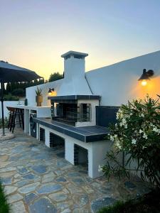 a outdoor grill sitting on a stone patio at LUZ BLANCA in Agios Leon