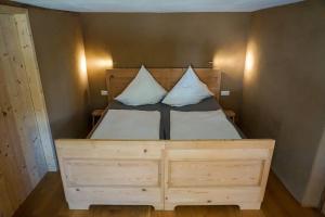 a bedroom with a wooden bed with two pillows at 5Sterne Ferienwohnung im Fachwerk mit Bergblick in Alleinlage und großem Garten, Infrarotkabine in Humberg