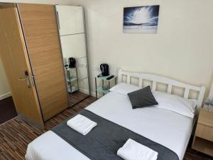 a bedroom with a bed and a wooden door at Namaste Palace Hotel in Norwich