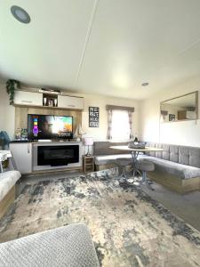 a living room with a couch and a television at Berwick Holiday Park Haven in Berwick-Upon-Tweed