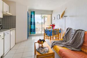 uma sala de estar com um sofá e uma mesa em Lagrange Vacances Les Résidences em Sainte-Marie-Plage