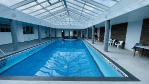 a large swimming pool in a building with a ceiling at Chalet 26 Widemouth Bay in Bude