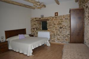 1 Schlafzimmer mit 2 Betten und einer Steinmauer in der Unterkunft La Casa de Rosa in Filiel