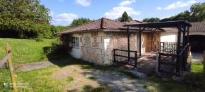 a small brick house with a wooden porch at Studio du moulin de Montizeau in Saint-Maigrin +22 photos