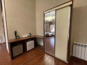 a large mirror in a room with a wooden floor at Vasiev's Hotel in Samarkand