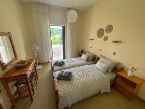 a bedroom with two beds and a desk and a mirror at Stay Corfu Studios in Sidari