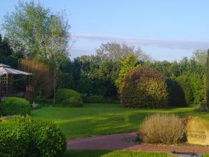 a garden with green grass and bushes and trees at Ferienwohnung Enzo in Langenhorn