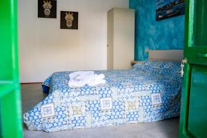 1 dormitorio con 1 cama con edredón azul y blanco en Zazzamita 2 0, en Catania