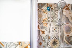 y baño con ducha y pared de azulejos. en Zazzamita 2 0, en Catania 35 fotos más