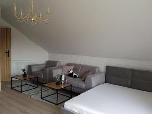 a living room with a couch and two tables at Villa Home Monika nad morzem in Wrzosowo