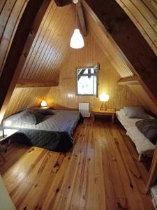 a attic bedroom with two beds and a window at CHALET 9 "Pensée" in Garin