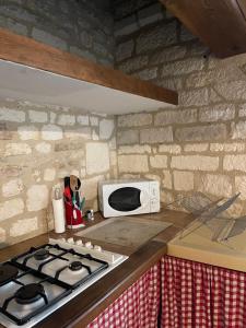 a kitchen with a stove and a microwave on a counter at La Maison d'Alienor, Gite à Chablis in Chablis