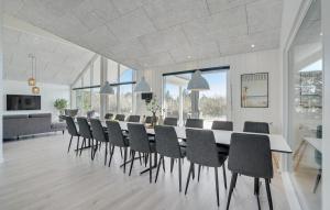 a large dining room with a long table and chairs at Lovely Home In Væggerløse With Sauna in Marielyst