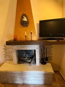 a living room with a fireplace with a flat screen tv at La casetta - Casa vacanze in Montenero Val Cocchiara