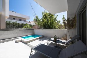 a patio with a swimming pool and two chairs at Nikiti Summer Gem 1 by Luxlikehome in Nikiti