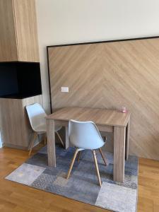 a wooden table and two white chairs in a room at Oasis of Energy in Ljubljana