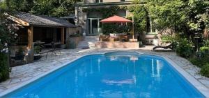 a large blue swimming pool in front of a house at La Roseraie in Tournai