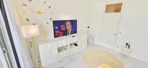 a bathroom with a tv on a white wall at Let's RelaxX Luxury class in Mülheim an der Ruhr