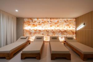 a room with three beds and a stone wall at Spa & Pool - Studio Apartments 365 in Tirana +133 photos