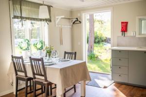 a dining room with a table with chairs and a window at Hummelfjärden Öregrund in Östhammar
